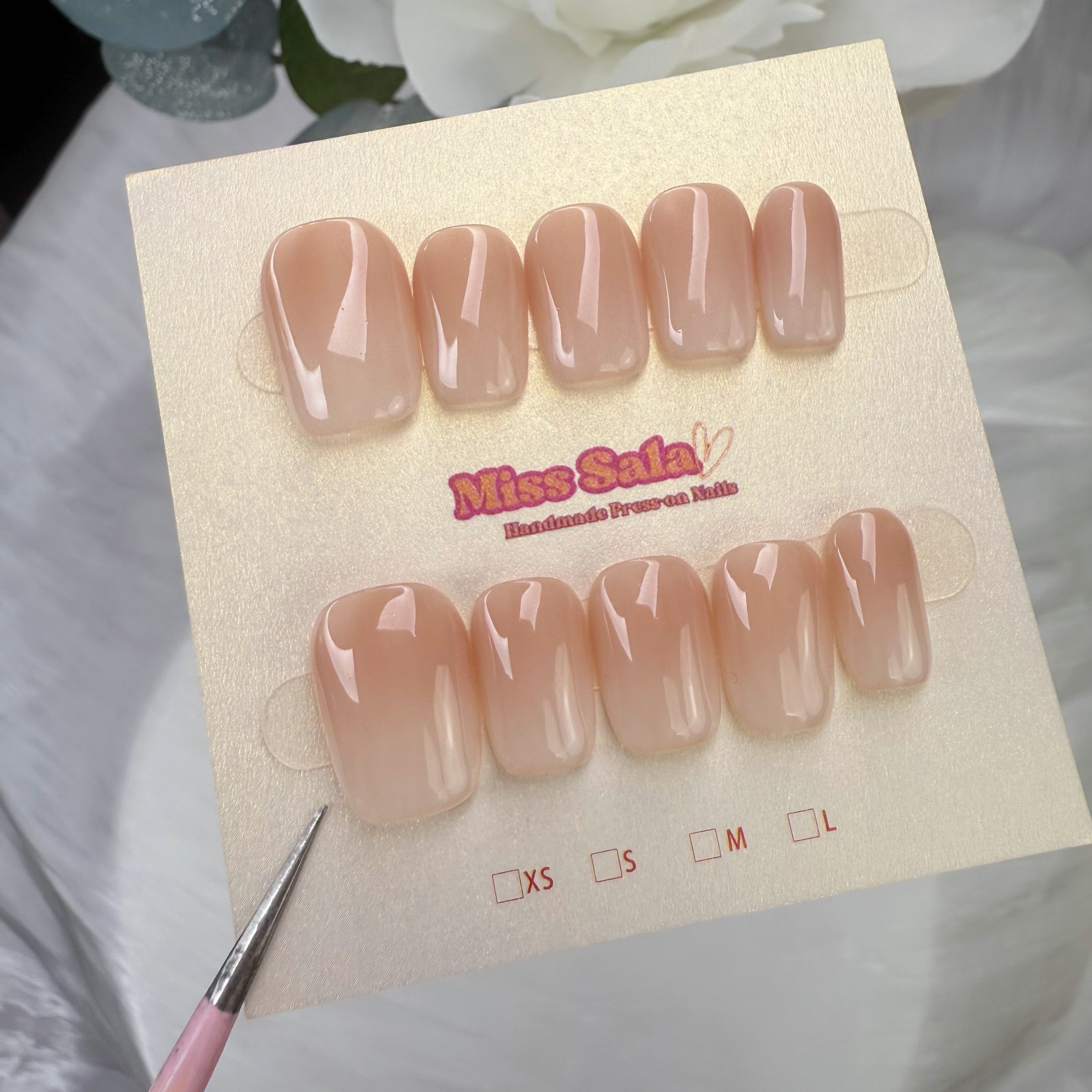 Short square press-on nails with a glossy nude-to-white ombre gradient finish, featuring a seamless transition from a soft tan base to milky white tips.