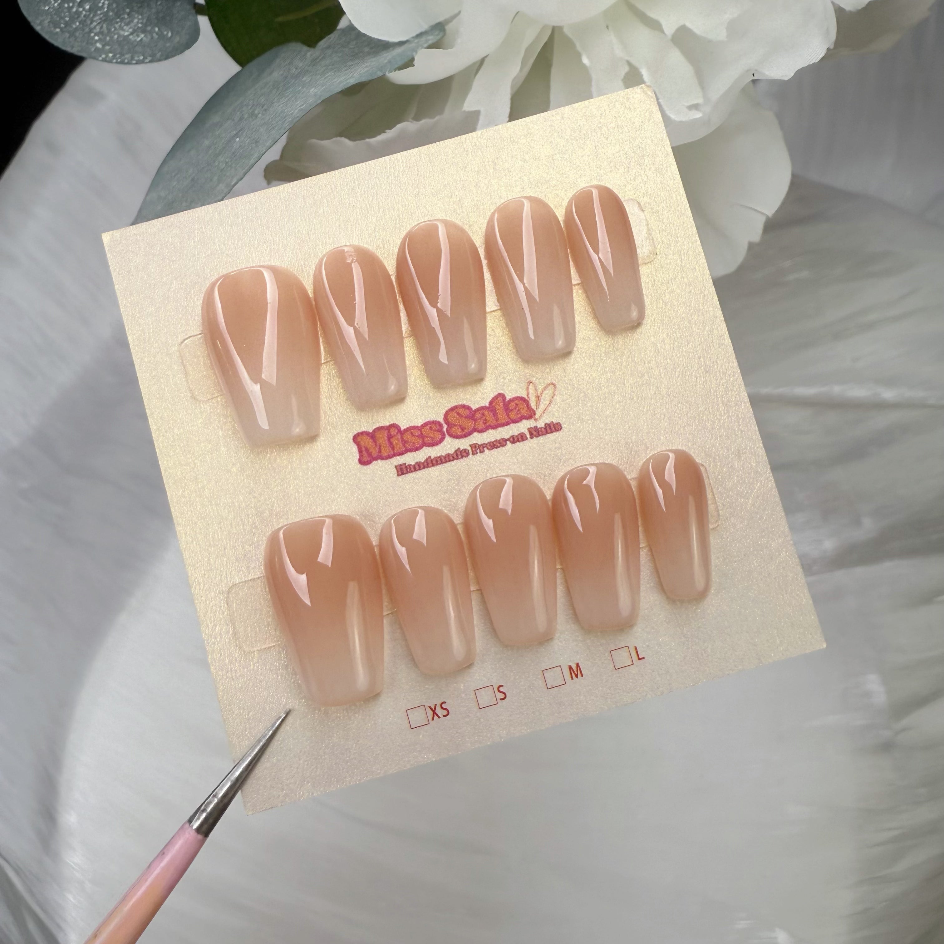 Medium square press-on nails featuring a glossy nude-to-white ombre gradient with a seamless, high-shine transition.