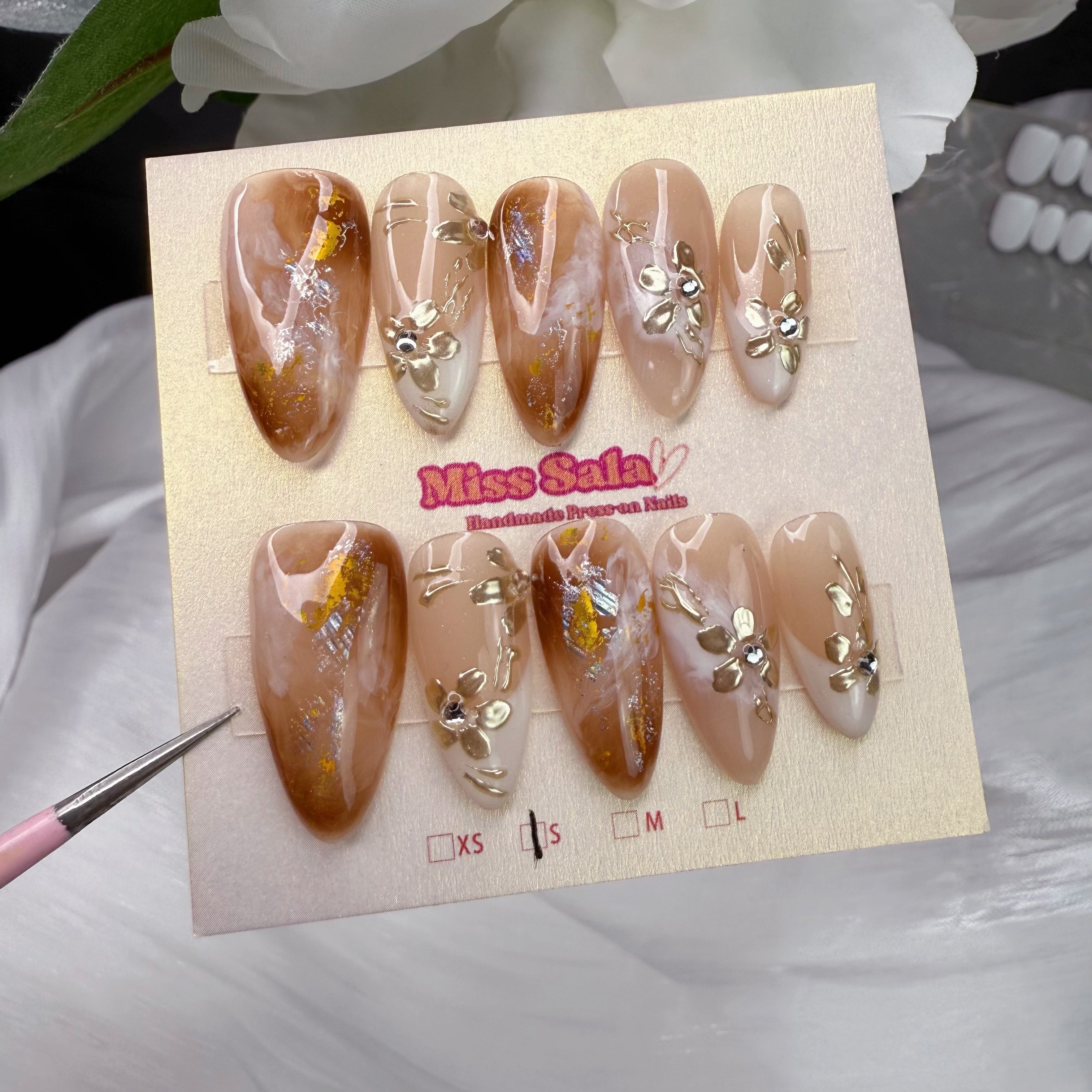 Almond-Shaped Press-On Nails with Amber Marble Base, 3D Gold Floral Art, Gold Leaf Flakes, and Sparkling Rhinestone Accents