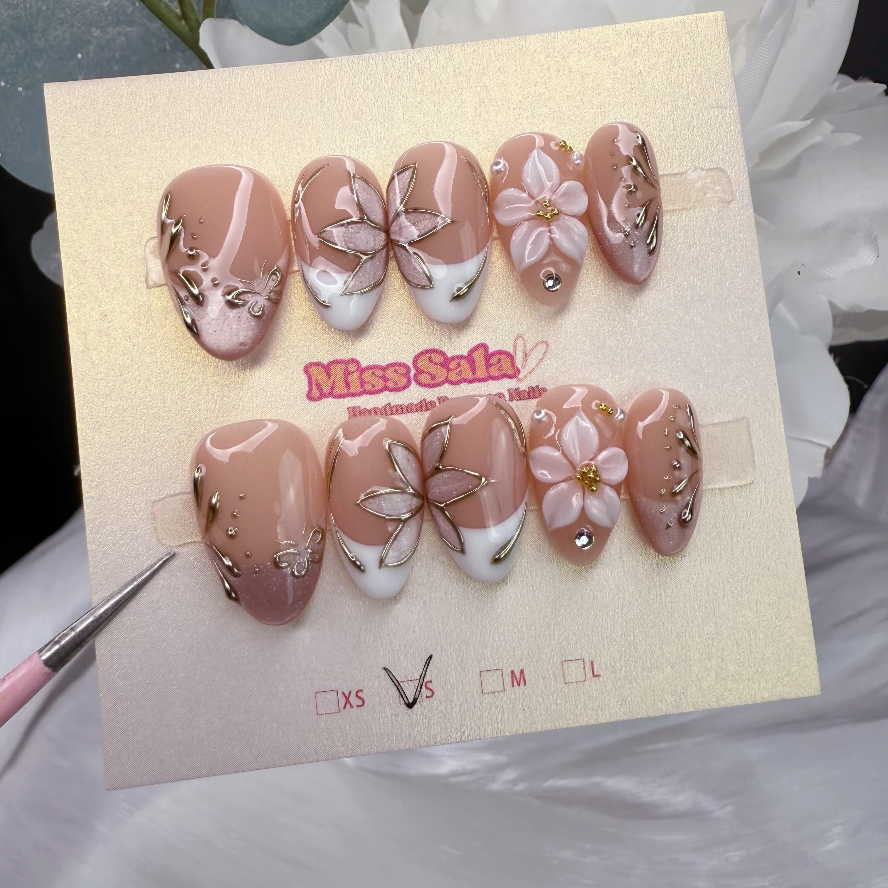 Nude Almond Press-On Nails with White French Tips, 3D White Flowers with Gold Centers, and Intricate Silver Metallic Butterfly Art