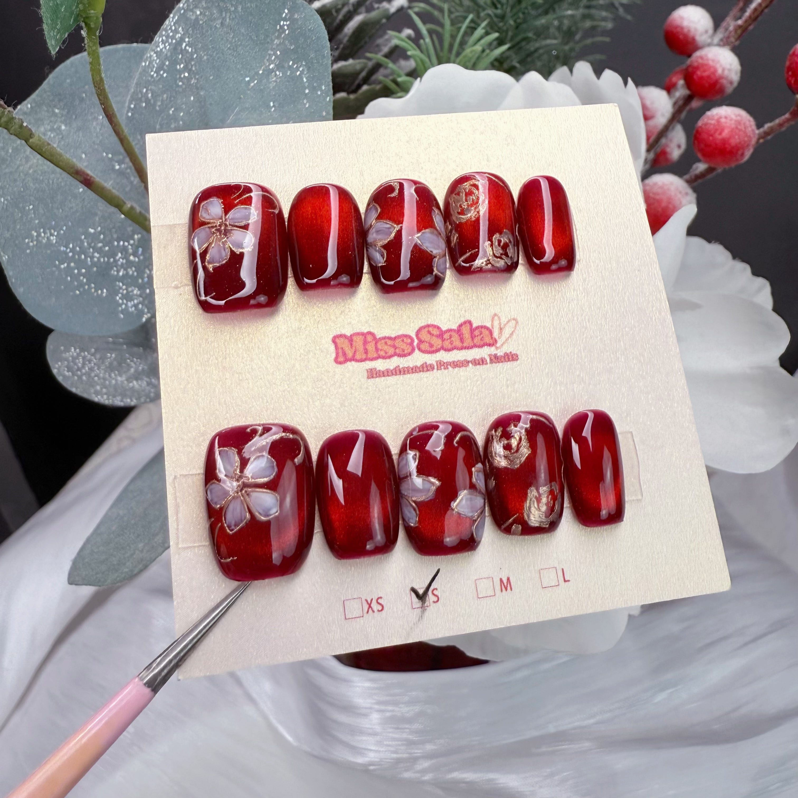 Crimson Sakura Silk handmade almond press on nails with deep red base and white cherry blossom floral art