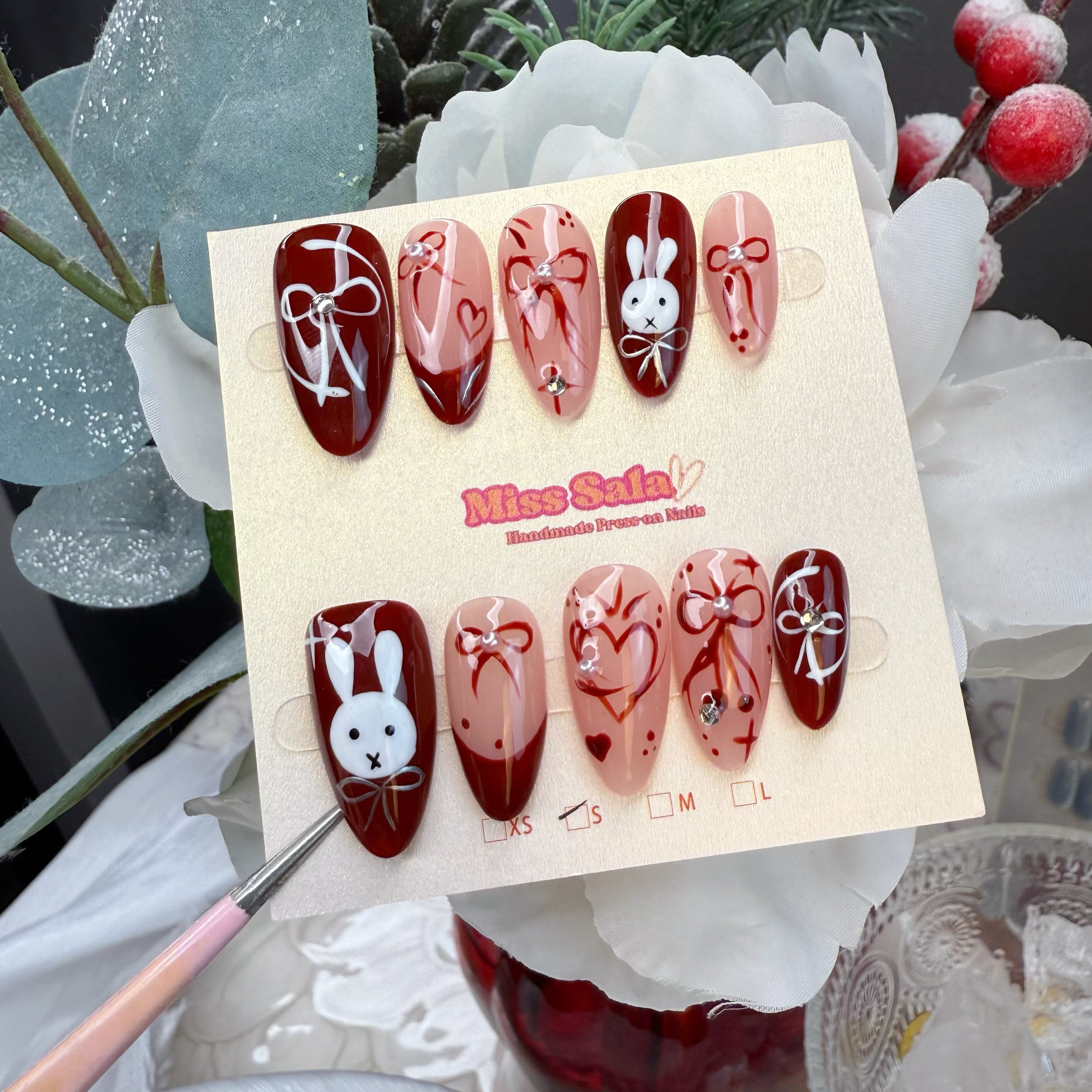 Almond-Shaped Press-On Nails in Cherry Red and Nude with Hand-Painted White Bunnies, Red Ribbon Bows, and Heart Art