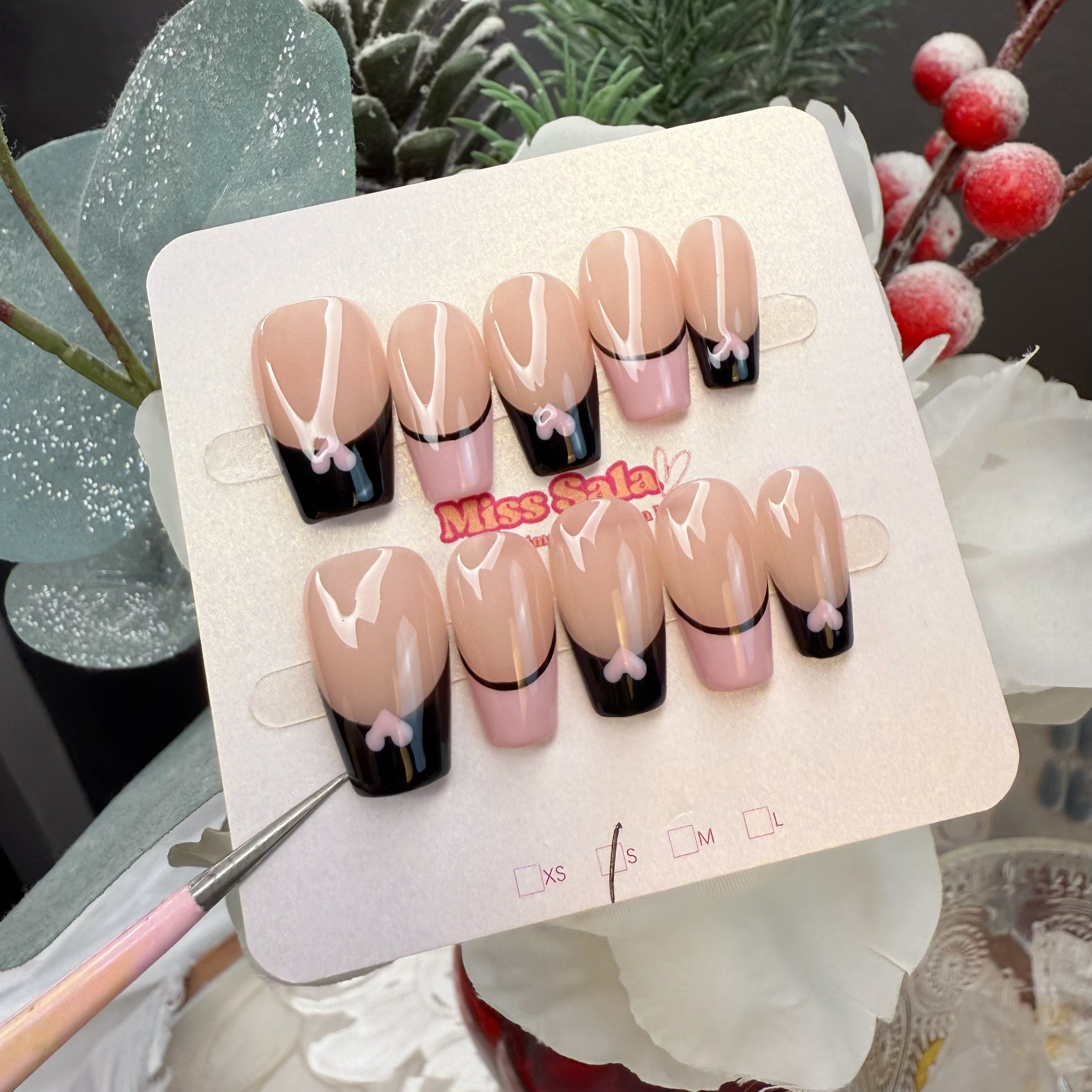 Medium Square Press-On Nails with a Nude Base, Alternating Black and Pink French Tips, and Small Contrast Heart Accents at the Center Base of Each Tip