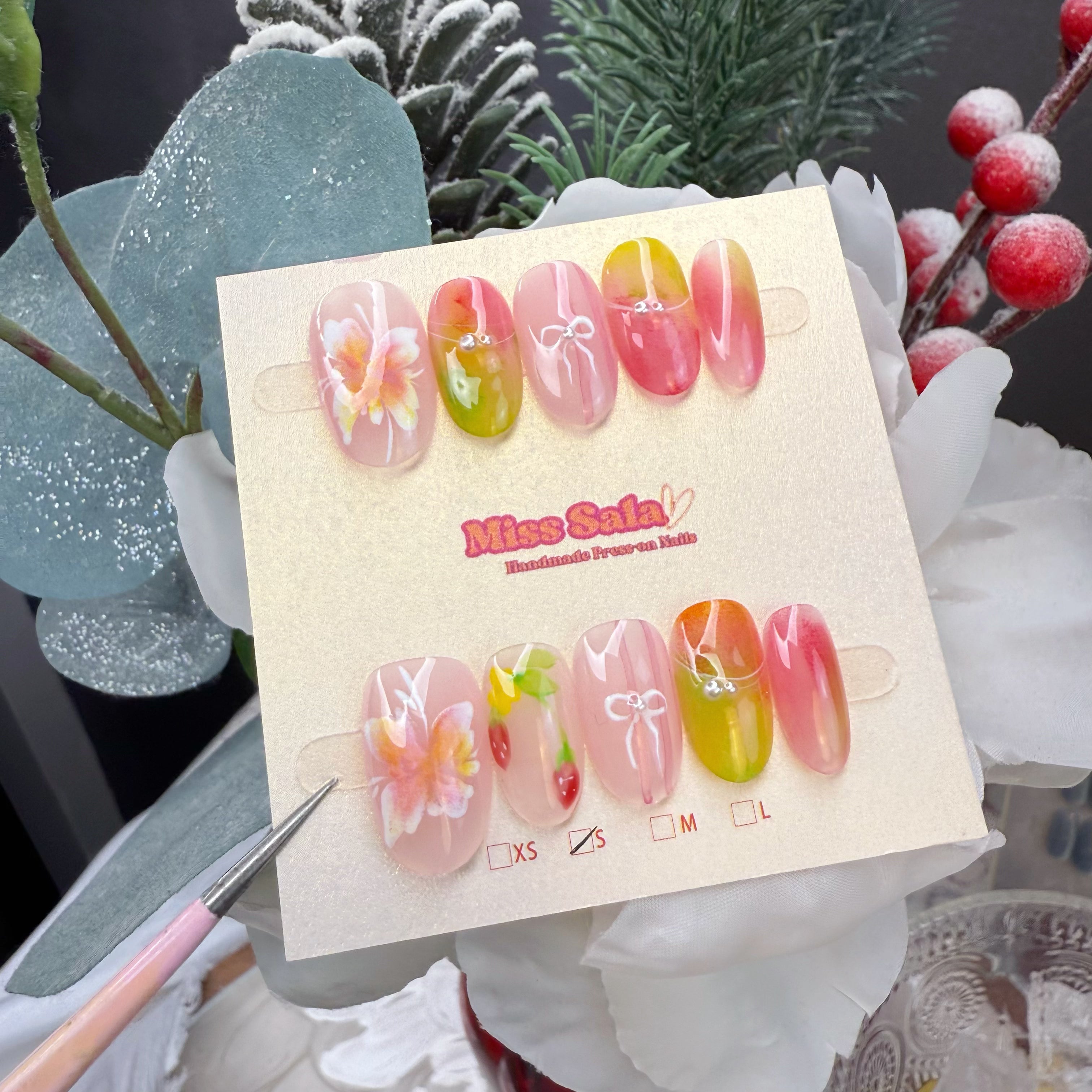 Short almond press-on nails featuring a vibrant pink, orange, and lime green aura gradient, hand-painted tropical hibiscus flowers, and delicate white bow accents.