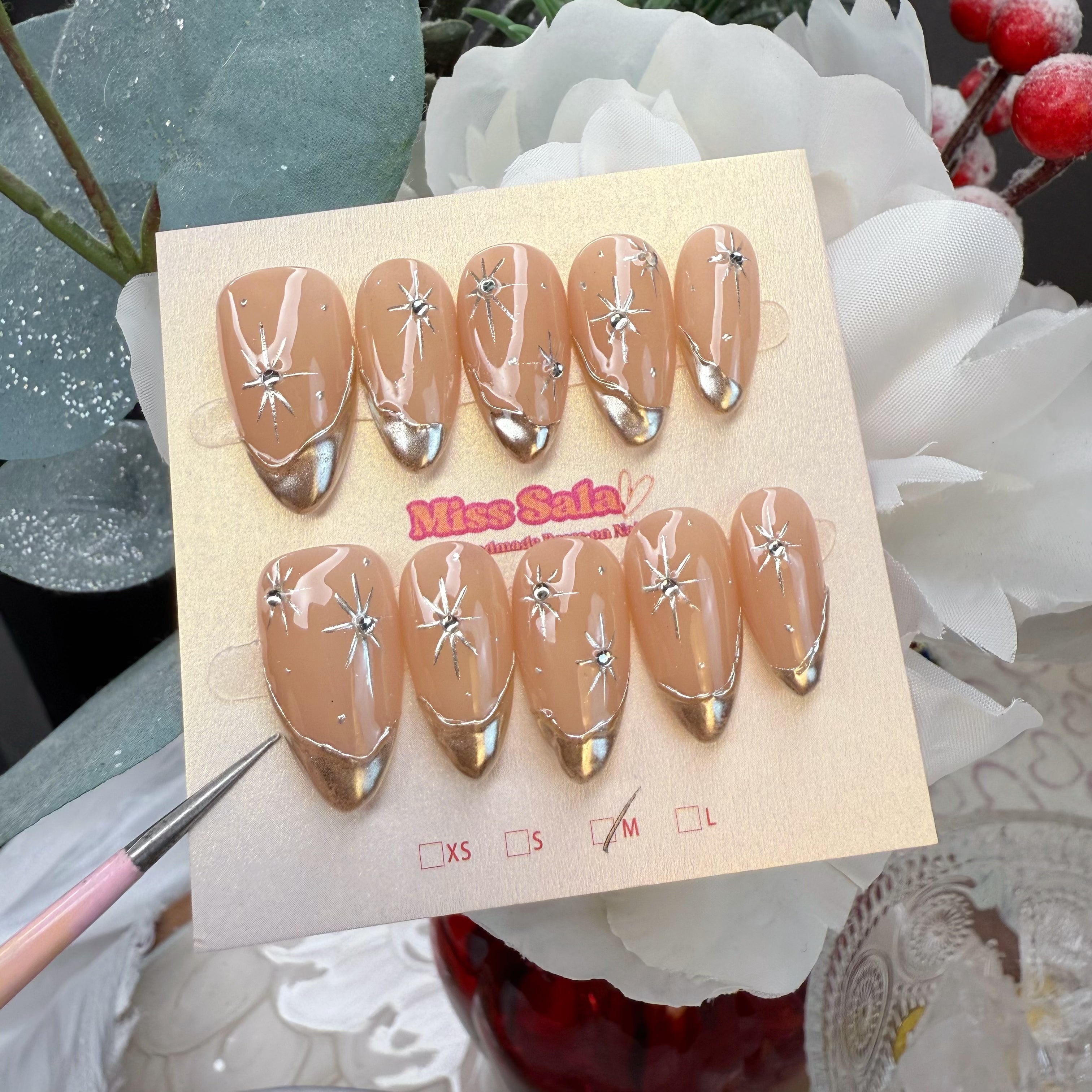 Almond-Shaped Press-On Nails with Nude Base, Metallic Gold Chrome French Tips, and Hand-Painted Gold Starburst Accents