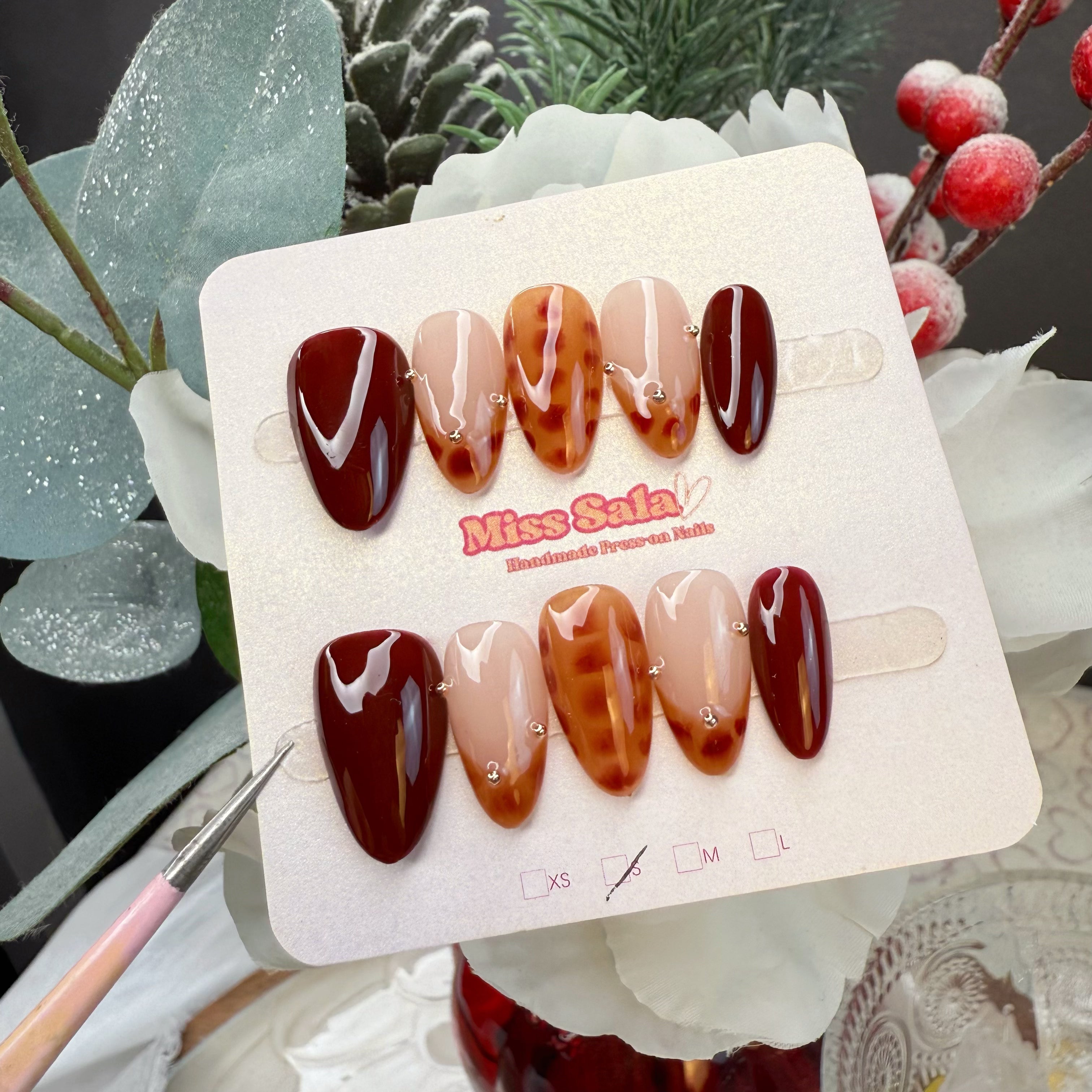 Almond Shaped Press-On Nails in Deep Ruby Red and Translucent Amber Tortoiseshell Pattern with Silver Micro-Stud Accents