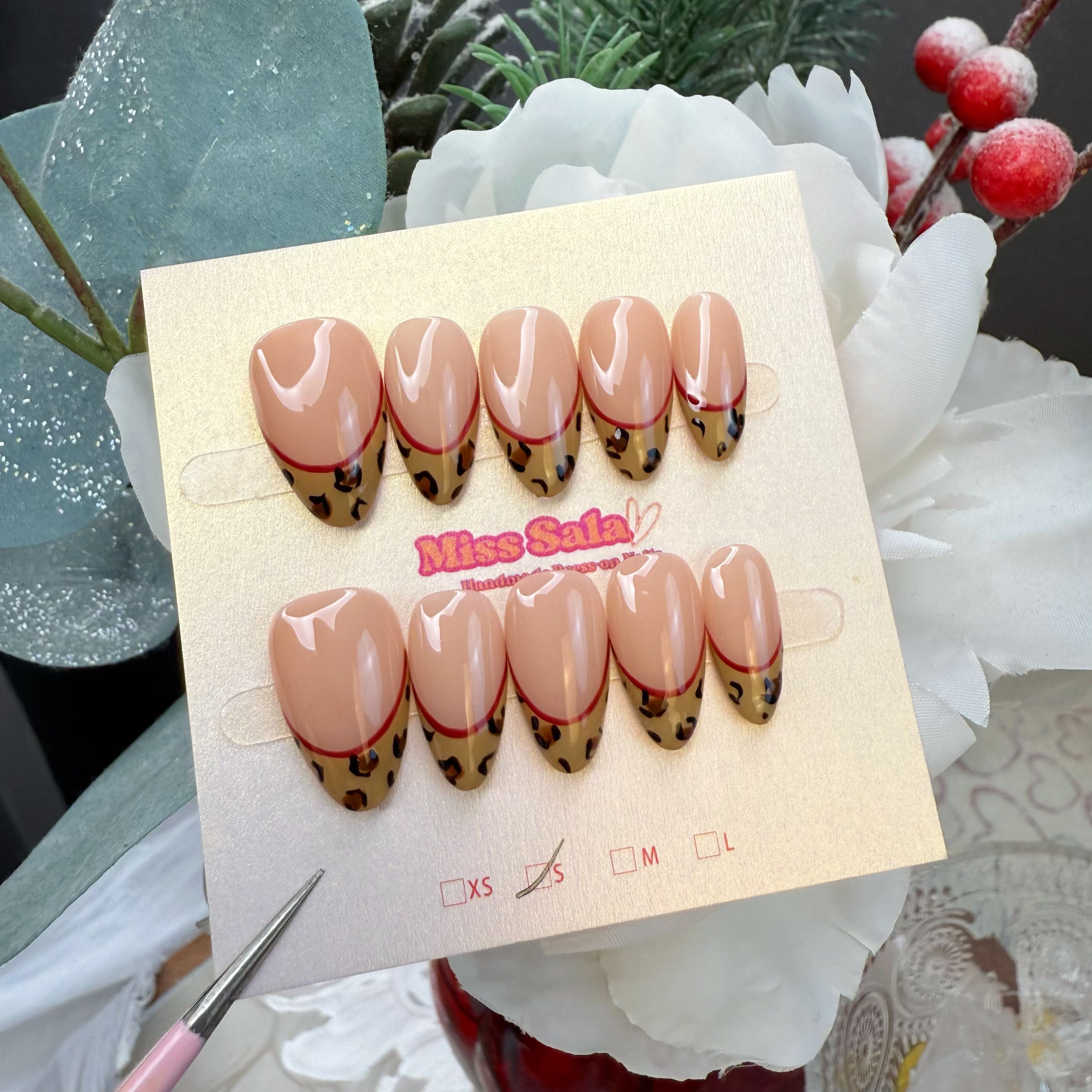 Almond-Shaped Press-On Nails with Nude Base, Hand-Painted Cheetah Print Tips, and a Vibrant Red Smile Line Detail