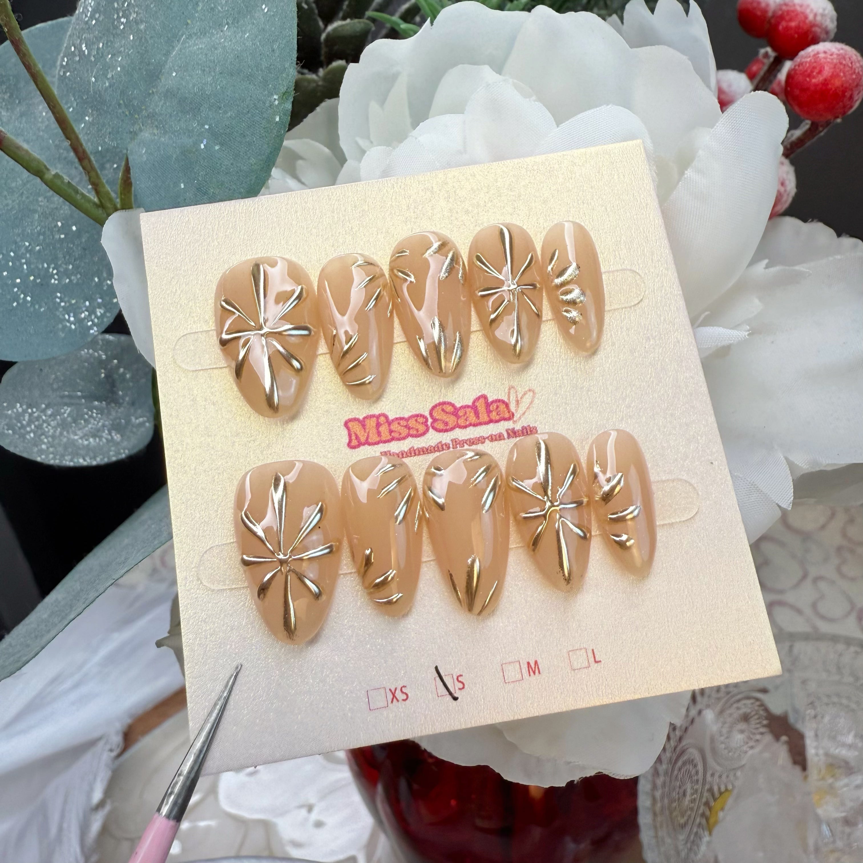 Almond-Shaped Press-On Nails with a Nude Base and Intricate 3D Metallic Gold Sunburst and Radiant Line Art